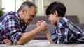 Loving father and kid arm wrestling on the floor, weekend leisure at home, fun Royalty Free Stock Photo