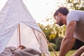 Loving Father Looking In On Son Sleeping Inside Tent Or Tepee Pitched In Garden Royalty Free Stock Photo