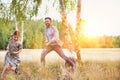 Loving father playing with his daughter in the woods whilst his wife watches and his happy Royalty Free Stock Photo