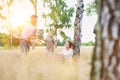 Loving father playing with his daughter in the woods whilst his wife watches and his happy Royalty Free Stock Photo