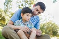 Loving Father Puts a Bandage on the Knee of His Upset Son