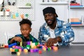 Loving Father Teaches and Plays with Son at Home for Learning and Education on Counting Cube in Math and Skill Development. Father