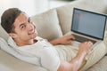 Loving the freedom of living wirelessly. Portrait of a relaxed young man using a laptop on the sofa at home. Royalty Free Stock Photo