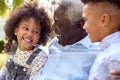 Loving Grandfather Talking With Grandchildren In Garden At Home