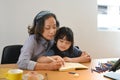 Loving grandmother embracing little granddaughter and drawing together at home Royalty Free Stock Photo