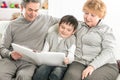 Loving grandparents with grandchild sitting on sofa