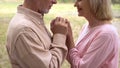 Loving grandparents looking each other, holding hands, caring spouse support