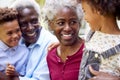 Loving Grandparents Talking With Grandchildren In Garden At Home