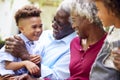 Loving Grandparents Talking With Grandchildren In Garden At Home