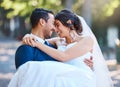 Loving groom carrying his bride in his arms in nature. Happy romantic couple enjoying their wedding day. Beautiful bride Royalty Free Stock Photo