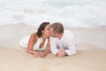 Loving groom kissing bride's mouth on beach