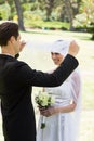 Loving groom lifting veil of bride