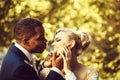 Loving groom touches face of adorable bride