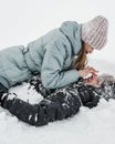 Loving guy and girl are lieing in the snow. Young happy couple walking in winter