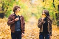 Loving happy couple in autumn in park holding autumn maple leaves in hands. Royalty Free Stock Photo