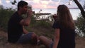 Loving happy couple drinking red wine near sea beach during sunset time. Media. Man and woman chatting while sitting on Royalty Free Stock Photo