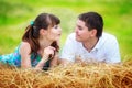 Loving happy couple having fun in a field on a haystack. Summer Royalty Free Stock Photo