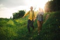 Loving hipster couple walking in the field, kissing and holding hands, hugging, lying in the grass in the summer at sunset. Royalty Free Stock Photo