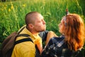 Loving hipster couple walking in the field, kissing and holding hands, hugging, lying in the grass in the summer at sunset. Royalty Free Stock Photo