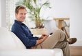 Loving his laid-back day at home. a handsome man using his tablet while sitting on the sofa at home. Royalty Free Stock Photo