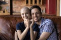 Loving husband hugging wife cancer patient on sofa at home Royalty Free Stock Photo