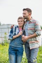 Rear photo of a loving husband and wife farmers looking locing over their beautiful farm