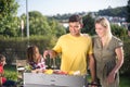 Loving husband and wife making BBQ in backyard