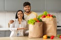 Loving indian couple showing bags full of fresh fruits, vegetables Royalty Free Stock Photo