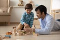 Loving Indian father and little son playing with toys together