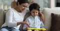 Little Indian boy and mother drawing on magnetic erasable board