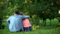 Loving male and female hugging sitting on grass in park, couple togetherness Royalty Free Stock Photo