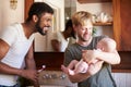 Loving Male Same Sex Couple Cuddling Baby Daughter In Bathroom At Home Together Royalty Free Stock Photo