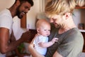 Loving Male Same Sex Couple Cuddling Baby Daughter In Bathroom At Home Together Royalty Free Stock Photo