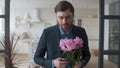 Loving man presenting bouquet of flowers to wife at home in slow motion.