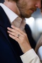 Loving man tenderly holds his girlfriend's hand, gazing into her eyes while gently touching her head. Woman wears Royalty Free Stock Photo