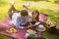 Happy married couple reading book together during picnic in countryside Royalty Free Stock Photo