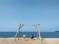 Loving married couple swinging on a swing on the beach. Siberia. Russia. Ob. Mobile photo. July, 12. 2020