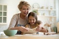 Caring grandmother baking pie with little 9s granddaughter Royalty Free Stock Photo