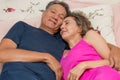 Loving Mature Couple in Bed Relaxing. Royalty Free Stock Photo