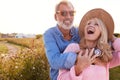 Loving Mature Couple In Countryside Hugging Against Flaring Sun Royalty Free Stock Photo