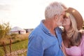 Loving Mature Couple In Countryside Kissing Against Flaring Sun Royalty Free Stock Photo