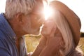 Loving Mature Couple In Countryside About To Kiss Against Flaring Sun Royalty Free Stock Photo