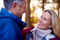 Loving Mature Retired Couple Hugging Against Autumn Countryside With Flaring Sun Royalty Free Stock Photo
