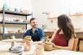Loving Couple Making Artwork In Pottery Class