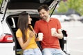 Loving millennial couple have break during road trip, drinking coffee Royalty Free Stock Photo