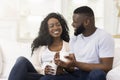 Loving millennial couple relaxing with cup of coffee at home Royalty Free Stock Photo