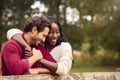 Loving Mixed Race Couple Leaning On Fence On Walk In Countryside