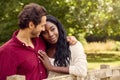 Loving Mixed Race Couple Leaning On Fence On Walk In Countryside