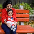 Loving mom carrying of her baby at society park. Bright portrait of happy mum holding child in her hands. Mother hugging her Royalty Free Stock Photo