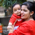 Loving mom carrying of her baby at society park. Bright portrait of happy mum holding child in her hands. Mother hugging her Royalty Free Stock Photo